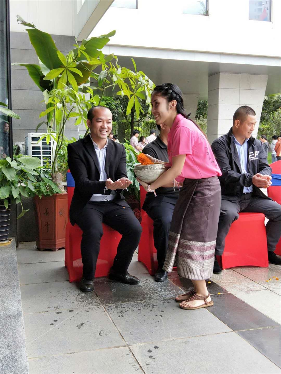 老撾駐廣西留學生代表將浸有花瓣的香水灑客人的手上，表示對嘉賓的美好祝福（圖一）