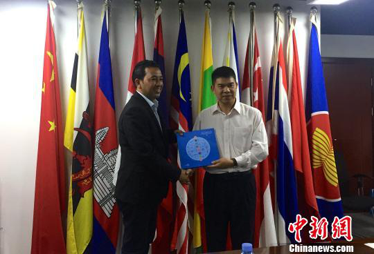 中國—東盟博覽會秘書處副秘書長黃平西（右）與柬埔寨新聞部新聞與傳播總司副總司長春占皮侖（左）互贈禮物。