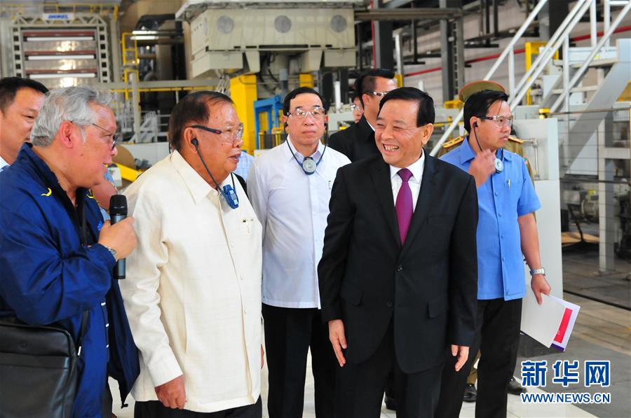 3月10日，在老撾沙灣拿吉省車邦縣，老撾人民革命黨中央總書記、國家主席本揚（左二）在山東太陽紙業股份有限公司董事長李洪信（右二）的陪同下視察公司。 新華社記者章建華攝